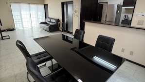 A conference room with a long table, black chairs, a sofa, and a large mirror on the wall.