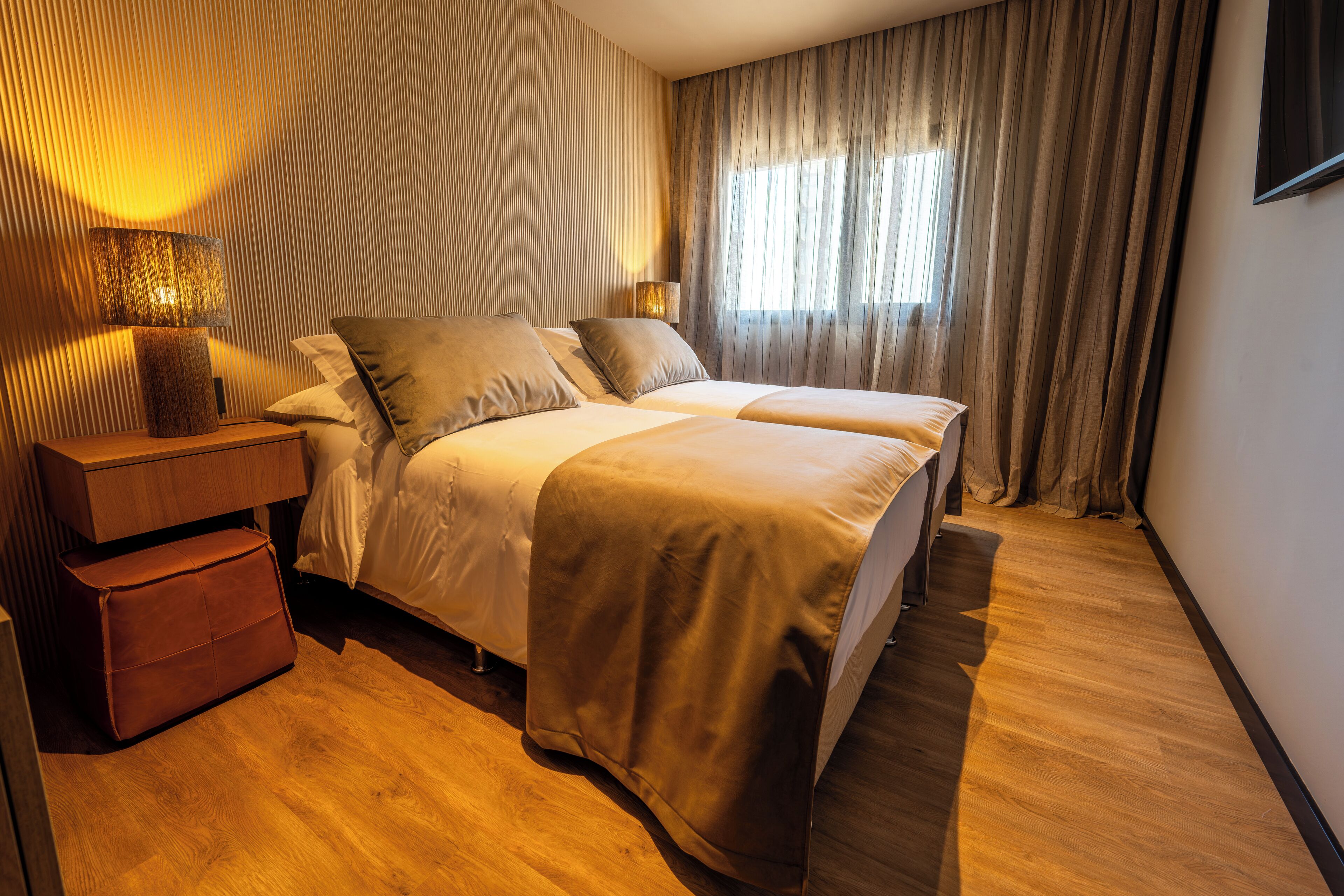 Et moderne hotelværelse med en stor seng, et sengebord og en lampe.