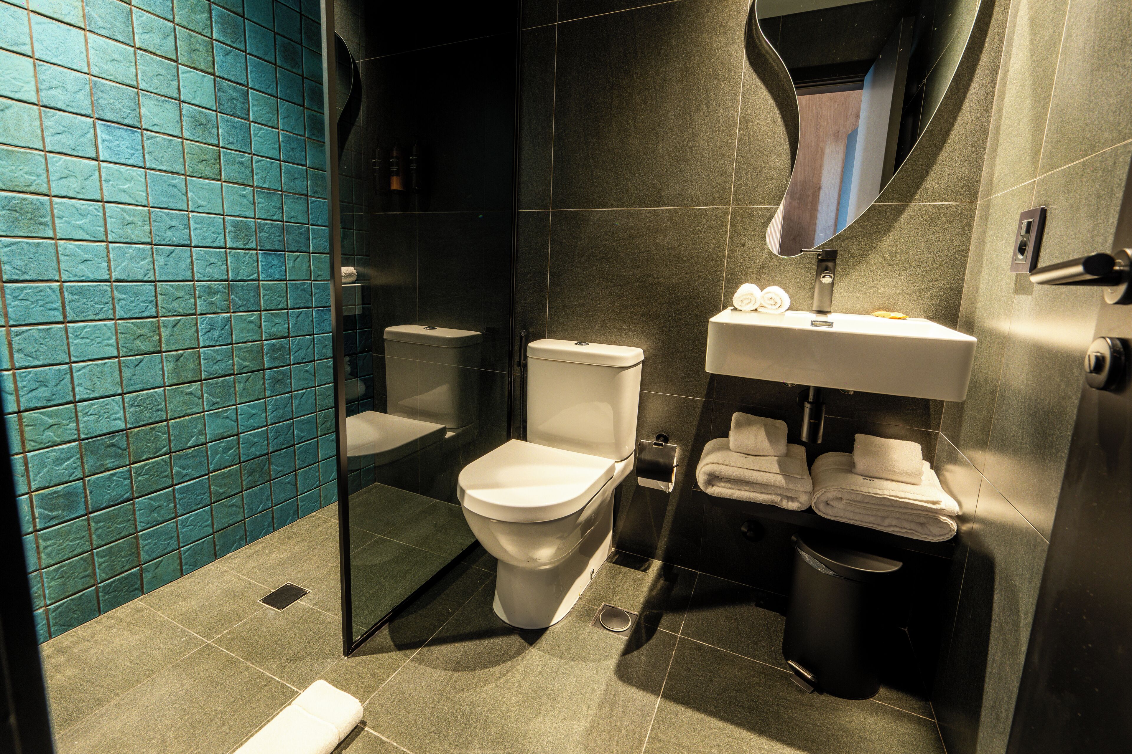 A modern bathroom with a toilet, sink, and glass shower enclosure.