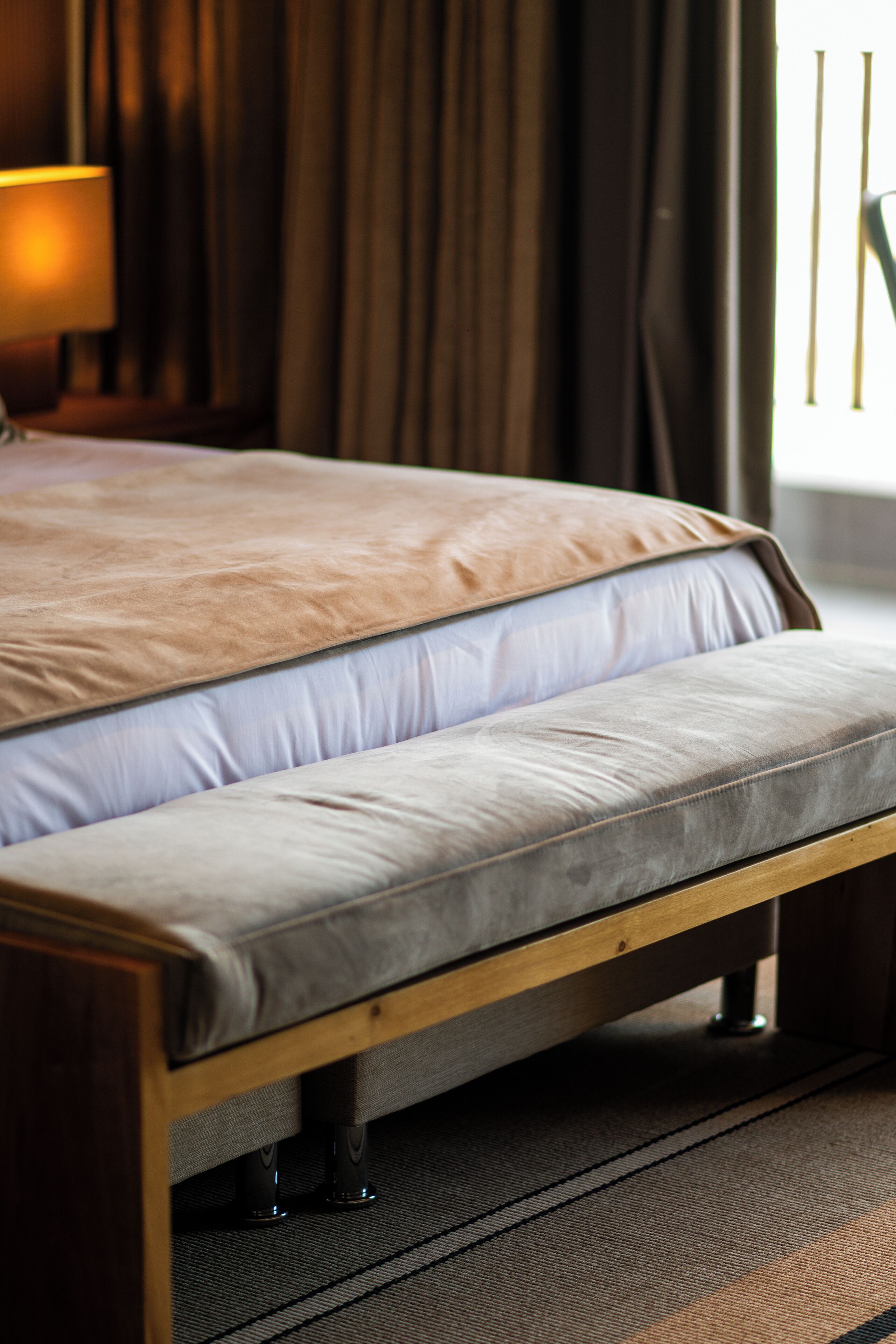 A bed with a wooden frame and a mattress with a light-colored cover.