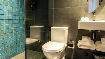 Un baño moderno con inodoro, lavamanos y espejo.