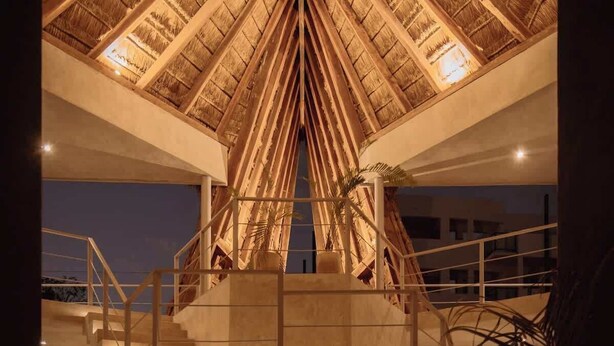 A building with a wooden, pyramid-like roof structure and a staircase leading to an upper level. - Seremonia Selva • Penthouse in the Jungle (Tulum)