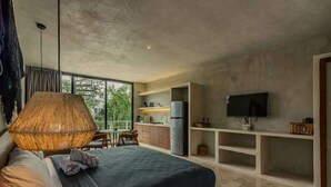 A modern bedroom with a large bed, a dining area, and a kitchen. - Seremonia Selva • Penthouse in the Jungle (Tulum)
