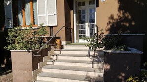Un conjunto de escalones de piedra que conducen a la entrada de un edificio, con una puerta y ventanas.