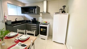 A compact kitchen with a microwave, stove, and refrigerator.
