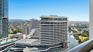 Un hotel moderno con varios pisos, un patio central y vistas a un río y al paisaje urbano.