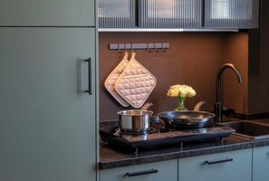 A modern kitchen with a built-in stove, a sink, and a backsplash.