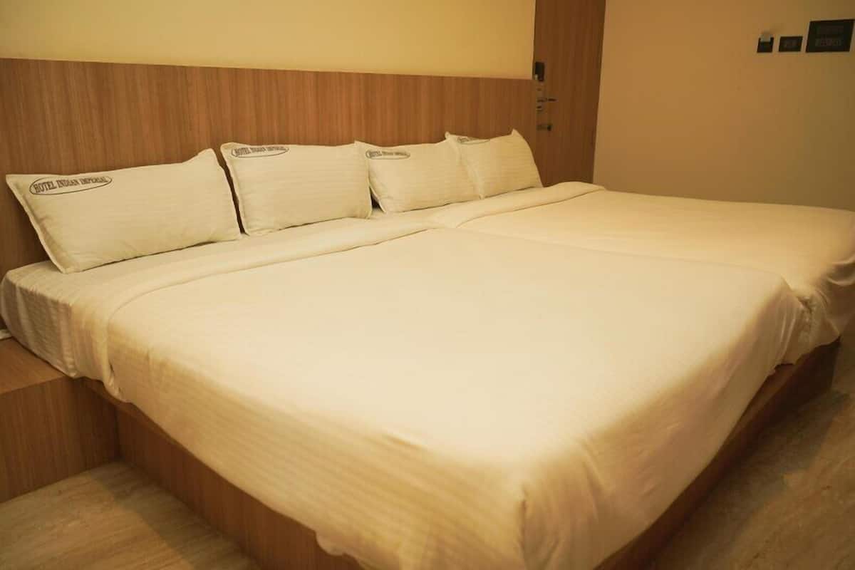 A large bed with a wooden headboard, multiple pillows, and a wooden nightstand.
