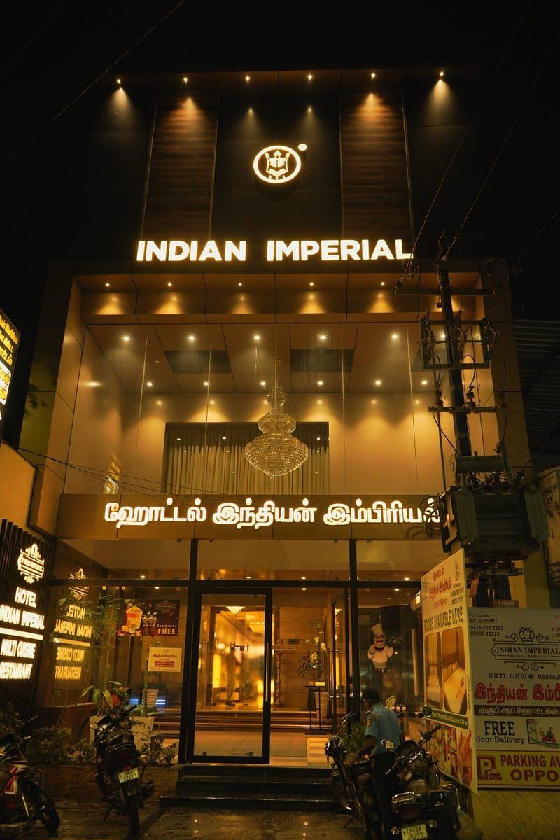 A building with a sign reading "INDIAN IMPERIAL" and another sign in a local language.