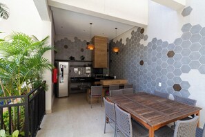 A modern kitchen with a hexagonal tile backsplash, wooden cabinets, and a built-in refrigerator. - Apto em Pinheiros c Piscina Academia e Smartlock (São Paulo)