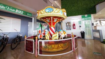 A carousel with a red and white striped pole, surrounded by gold accents and decorative elements.