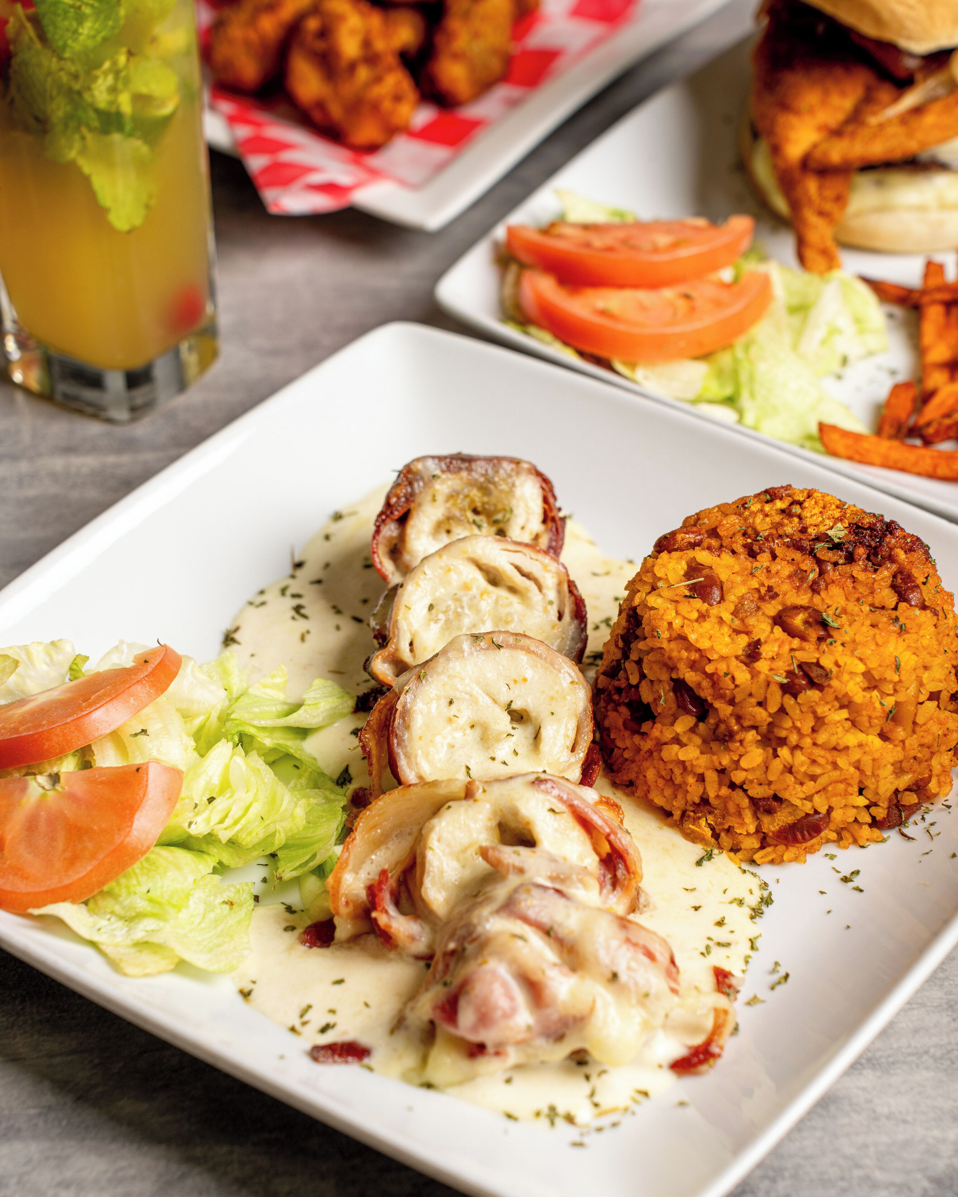 A plate with sliced chicken breast, rice, and vegetables.