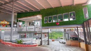 A hotel entrance with a green wall, a carousel, and a reception area. - Hotel Vista Verde (Yauco)