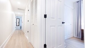 A hallway with white doors and a wooden floor.