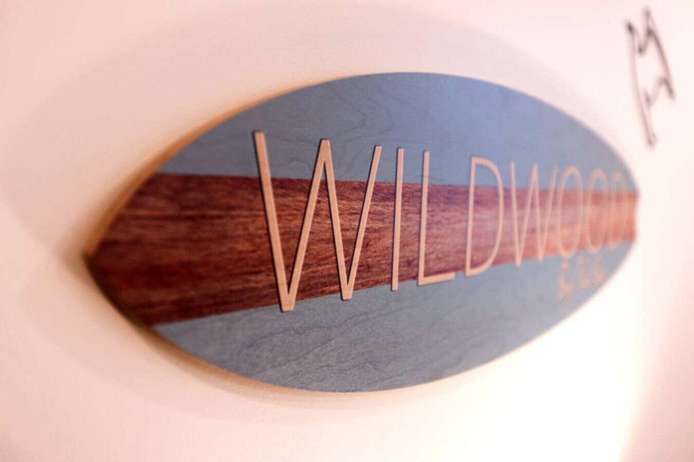 Ein hölzernes Schild mit dem Schriftzug 'WILDWOOD'.