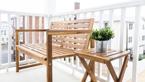 A wooden bench with a metal pot of green plants on a balcony with white railings. - 500 ft to boardwalk, 3 bdr condo (Wildwood)
