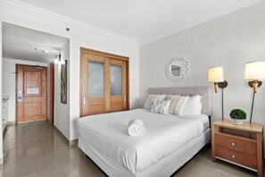 Una camera da letto con un letto, un comodino, uno specchio e una porta.