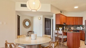 A modern kitchen with wooden cabinets, a round dining table, and a built-in island. - Beachfront Paradise 2BR Crescent Beach Seaside (Humacao)