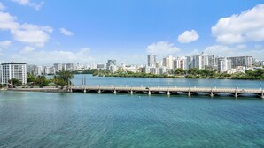 Une vue urbaine avec un pont enjambant une étendue d’eau, le tout entouré de bâtiments modernes.