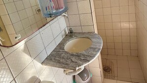 Kylpyhuoneessa on marmorinen pesuallas, wc, suihkutila ja ikkuna.
