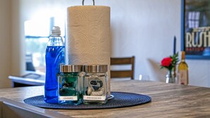A table with a blue bottle, two glass jars labeled 'laundry' and 'dishwasher', and a large roll of paper towels. - Gold Rush Charm Meets Modern Comfort (Rapid City)