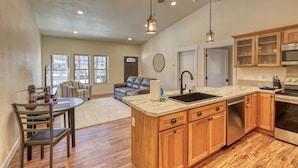 A spacious kitchen with wooden cabinets, a built-in oven, and a large island with a sink. - Gold Rush Charm Meets Modern Comfort (Rapid City)
