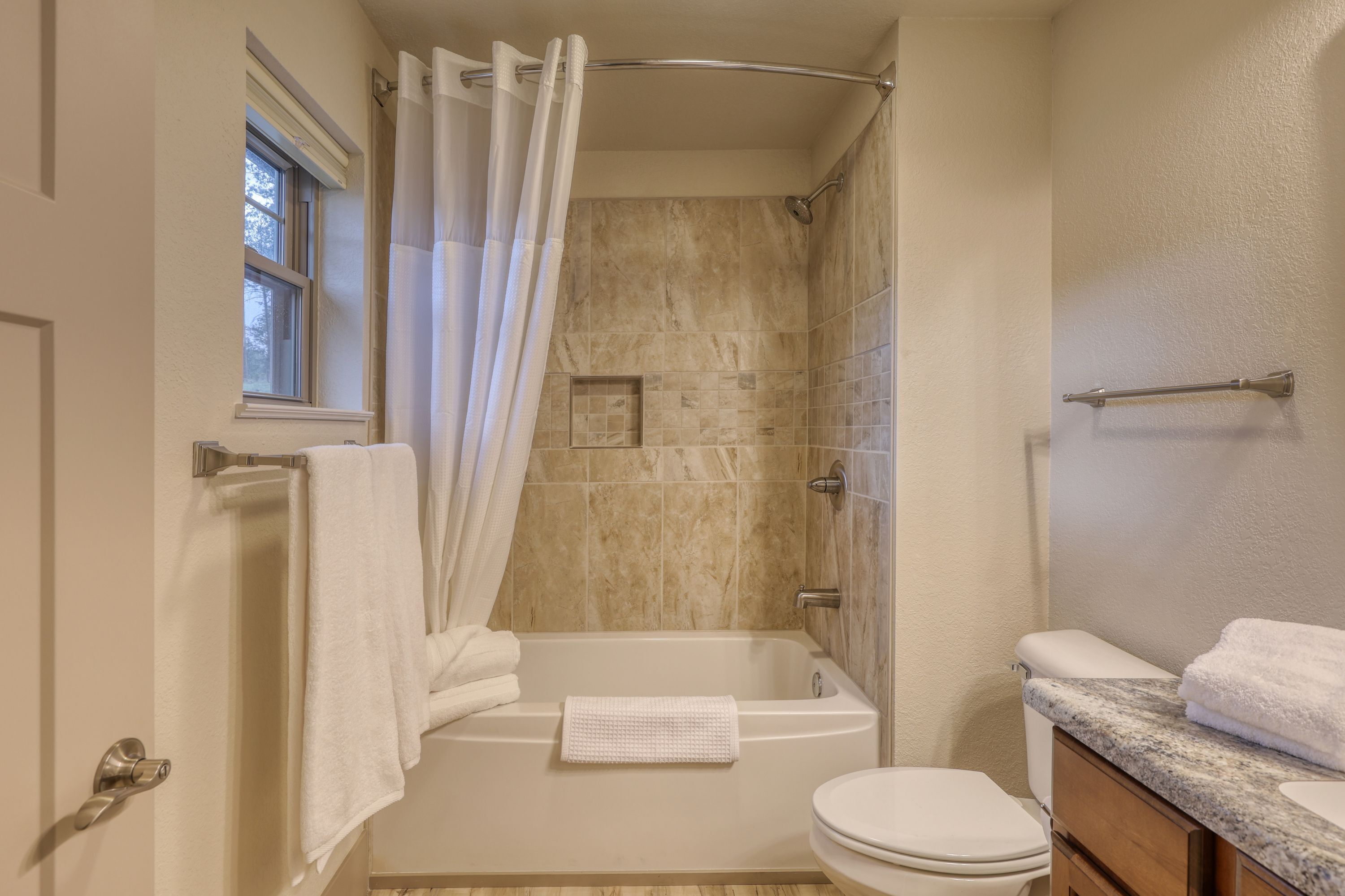 Un baño con bañera, inodoro y tocador.