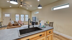 A spacious kitchen with a large island, wooden cabinets, and a ceiling fan. - Throttle Down in Style A Biker s Dream Stay (Rapid City)