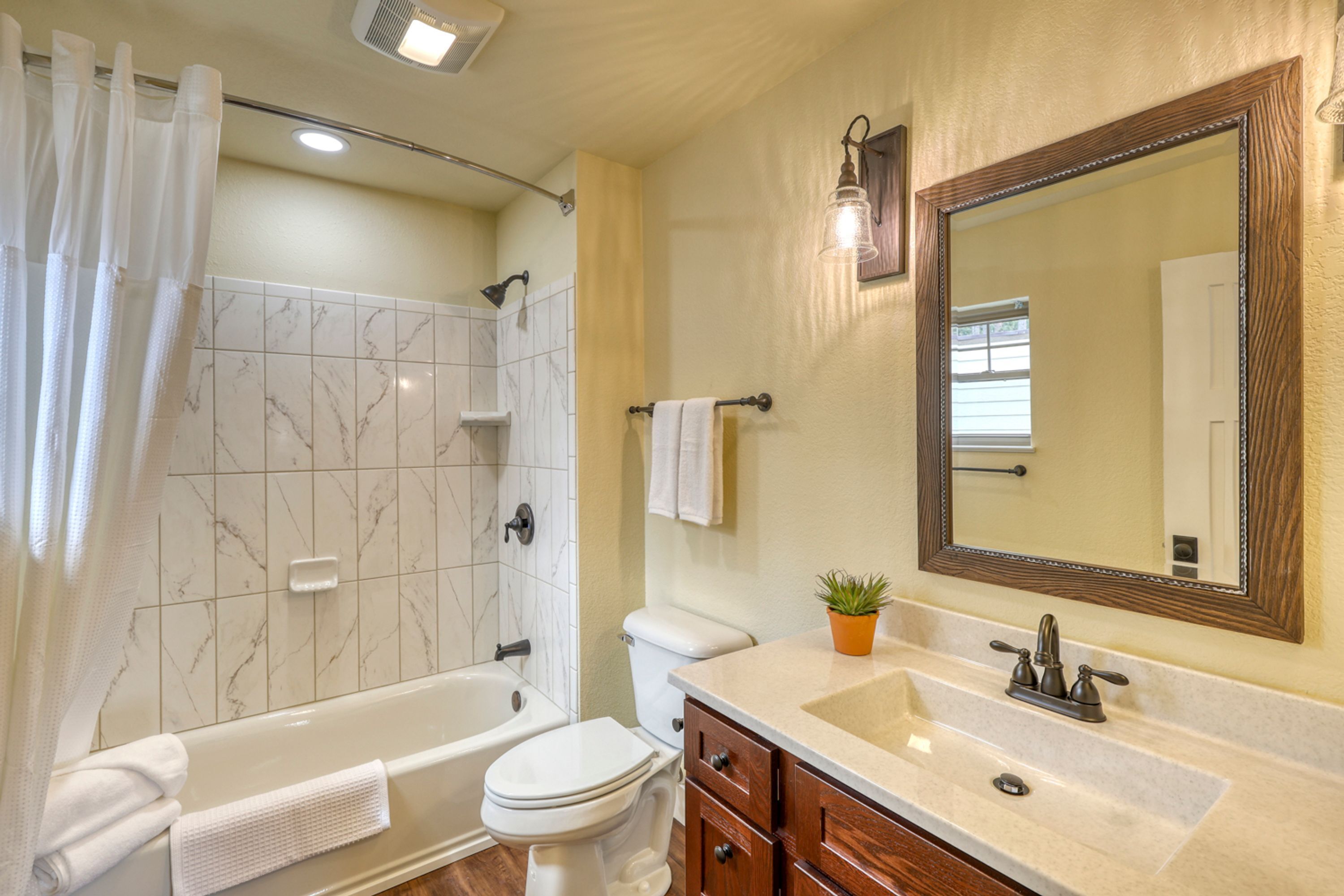 Un baño con bañera, inodoro y lavamanos.