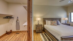 A bedroom with a wooden headboard, a bed with pillows, a nightstand with a lamp, and a window with natural light.