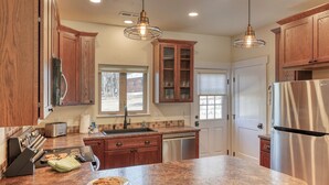 Una cocina moderna con armarios de madera, electrodomésticos de acero inoxidable y encimera de granito.