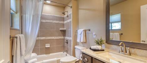 Une salle de bain équipée d’une baignoire, de toilettes, d’un lavabo et d’un miroir.