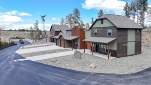 A residential area with multiple houses, a driveway, and a gravel path. - Modern Condo Near BH Attractions-garage Parking (Rapid City)