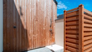 A wooden gate leading to a covered outdoor area with a concrete floor. - L'escale d'Erquy - Proche Plage (Erquy)