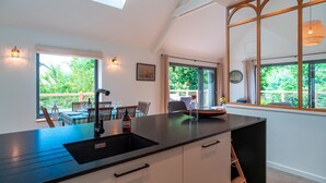 A modern kitchen with a black countertop, white cabinets, and a skylight. - L'escale d'Erquy - Proche Plage (Erquy)