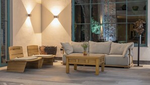 A modern interior with a sofa, two wooden chairs, a coffee table, and wall-mounted lights. - Rincon Del Montero (Parras de la Fuente)