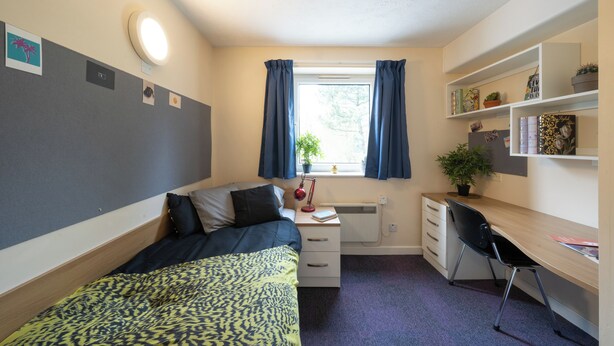 A compact room with a bed, a desk, and a window with curtains. - For Students Only Kimber Student Residence (Southampton)