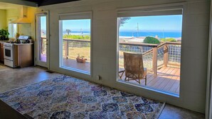 A spacious kitchen with a large window, a ceiling fan, and a view of the ocean. - Delightful 2-bedroom occuan view cottage , 5 minutes walk to the beach (Bodega Bay)