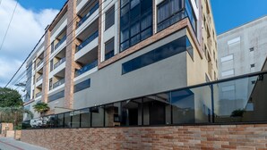 Un immeuble résidentiel à plusieurs étages, doté d’une façade en briques, de grandes fenêtres et de balcons.