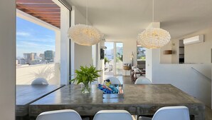 A modern dining area with a large table, white chairs, and pendant lights. - WhereInRio 4 suites luxury penthouse Ipanema (Rio de Janeiro)