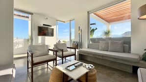 A modern living room with a sofa, chairs, a coffee table, and a TV mounted on the wall. - WhereInRio 4 suites luxury penthouse Ipanema (Rio de Janeiro)