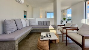 A modern living room with a sectional sofa, a coffee table, and a small round table with a lamp. - WhereInRio 4 suites luxury penthouse Ipanema (Rio de Janeiro)
