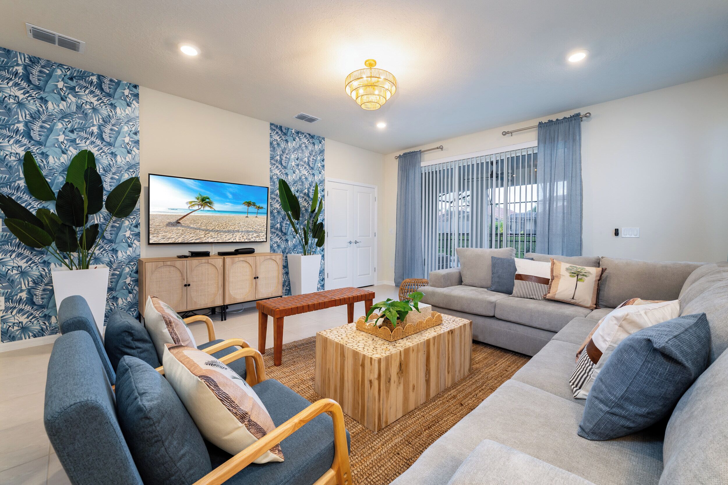 Ein modernes Wohnzimmer mit grauem Sofa, Couchtisch aus Holz und einem Flachbildfernseher.