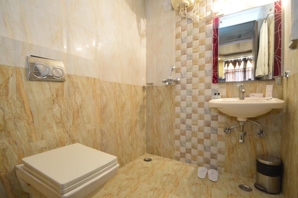 Une salle de bain avec un sol en marbre, un lavabo, un miroir et des toilettes.