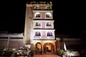 Ein mehrgeschossiges Gebäude mit einem Schild, auf dem 'HOTEL SURYA GARH' steht.