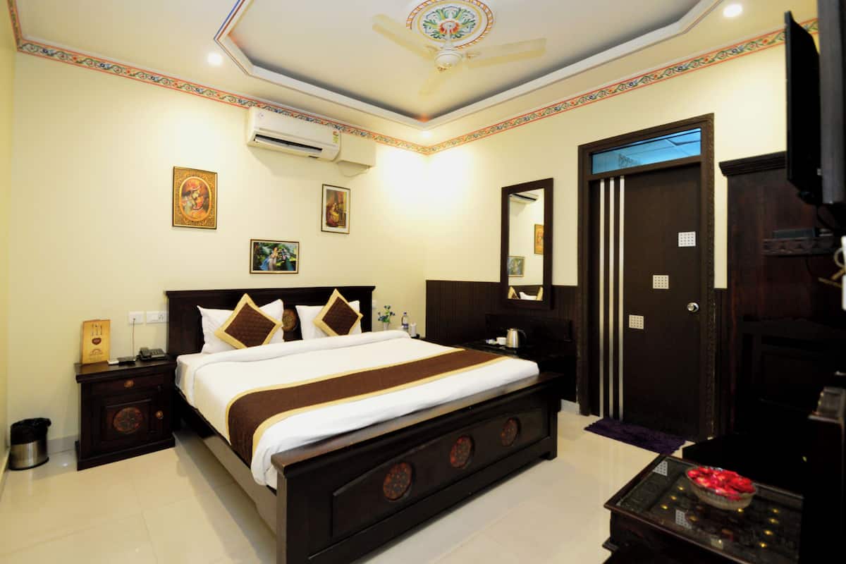 Une chambre d’hôtel avec un grand lit, une armoire, un bureau et un téléviseur.