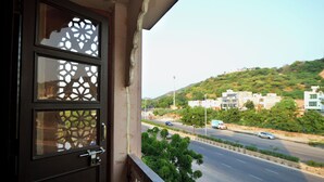 Un balcon donnant sur une route et des bâtiments situés sur une colline.
