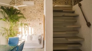 A staircase with a white wall and a textured brick wall in the background. - Cozy Renovated Apt with Delightful View/Old City (Cartagena de Indias)