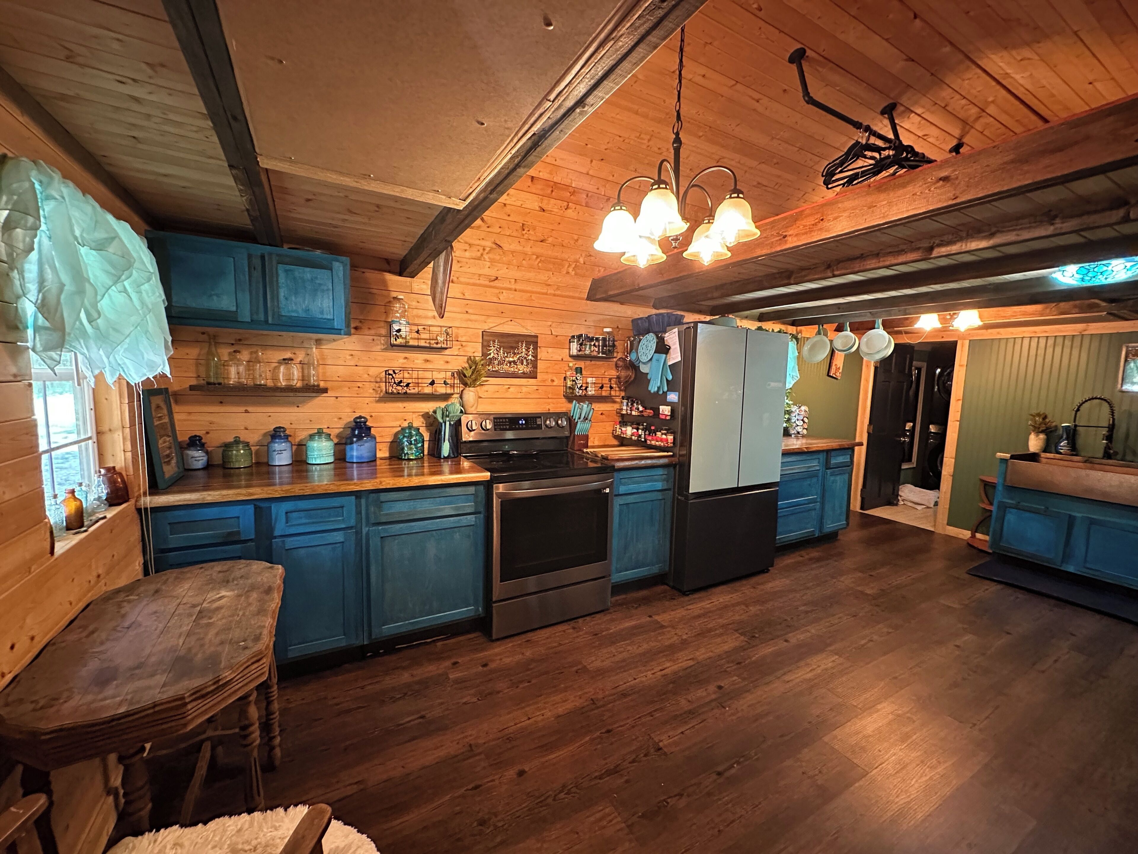 A kitchen with wooden cabinets, a refrigerator, an oven, and a dining table.