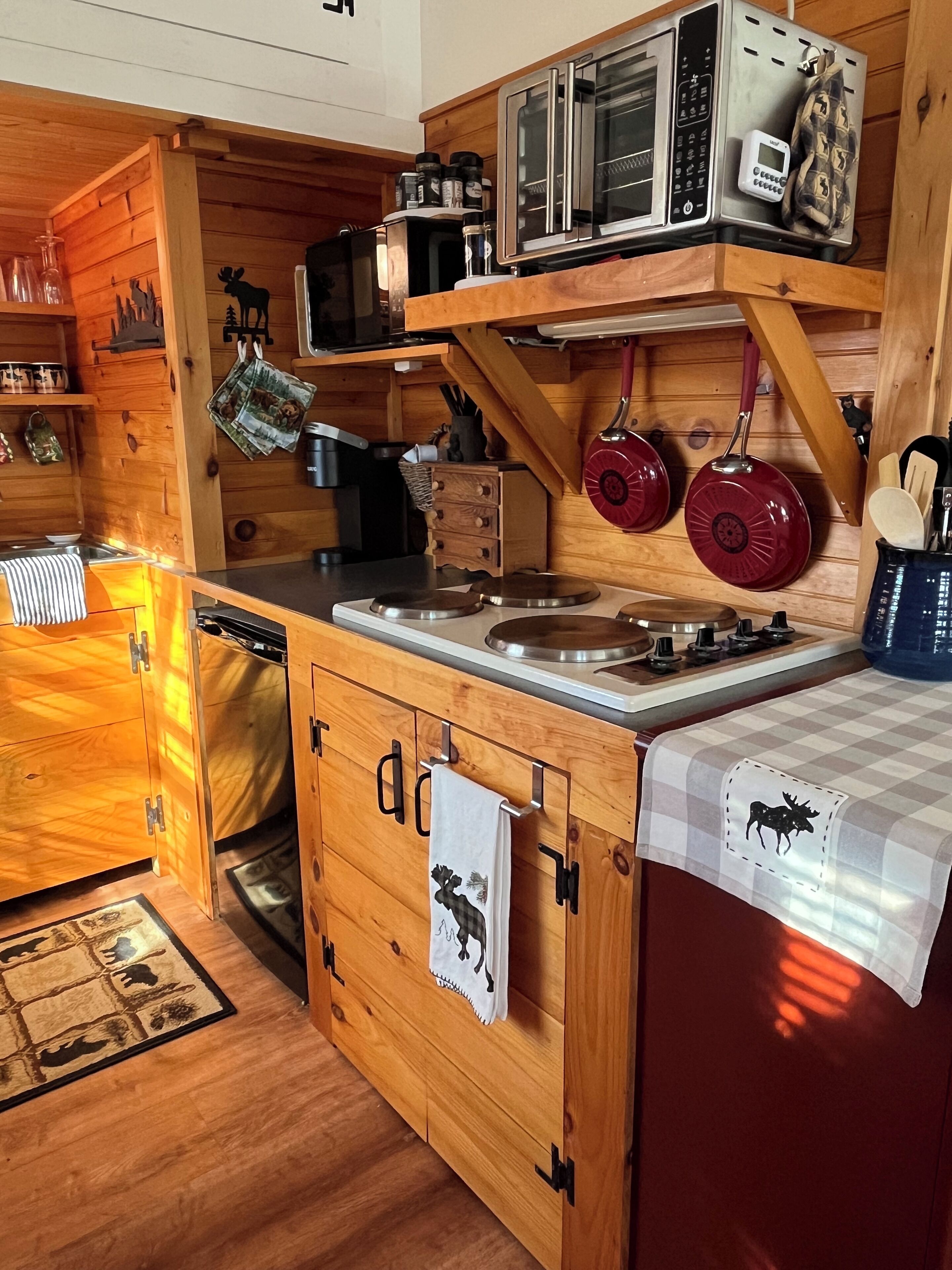 Une cuisine compacte dotée de meubles en bois, d’un four à micro-ondes, d’un grille-pain et d’une bouilloire.